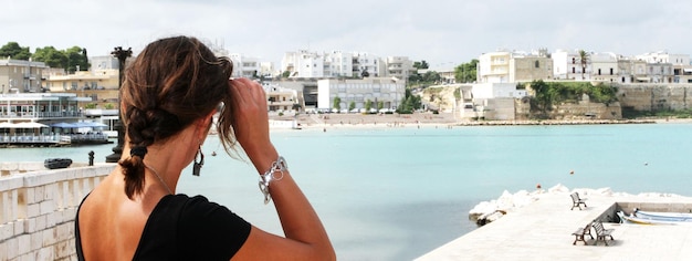 Beautiful tourist woman admires the historic port of Otranto Apulia Italy