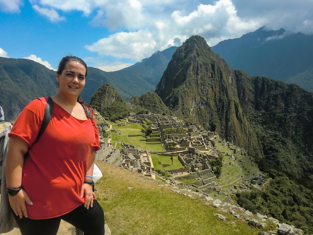 Beautiful tourist woman posing in the Sanctuary of Machu Picchu, Urubamba - Cusco - Peru.