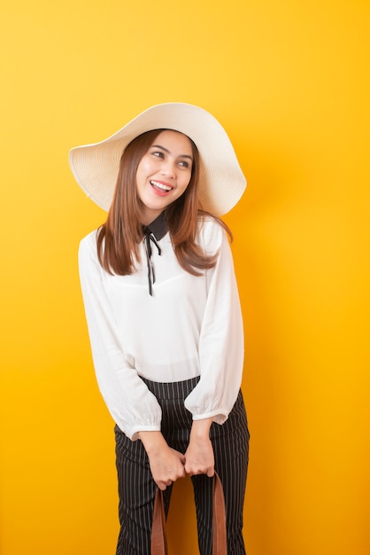 Beautiful traveler woman is exciting on yellow  wall 