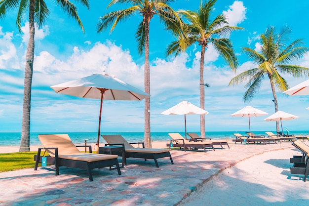 Beautiful tropical beach and sea with umbrella and chair around swimming pool in hotel resort for travel and vacation