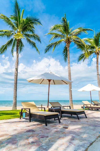 Beautiful tropical beach and sea with umbrella and chair around swimming pool in hotel resort