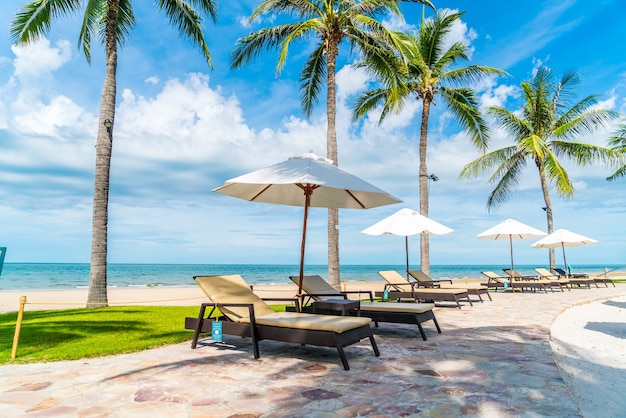 Beautiful tropical beach and sea with umbrella and chair around swimming pool in hotel resort