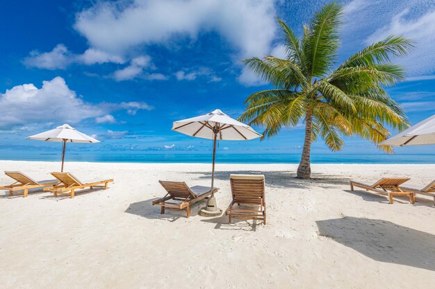 Beautiful tropical beach vacation. White sand and coco palms travel tourism, chairs umbrella.