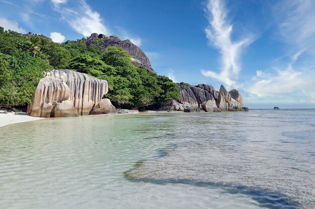 Beautiful tropical beach with sculpted granite rocks and palm trees