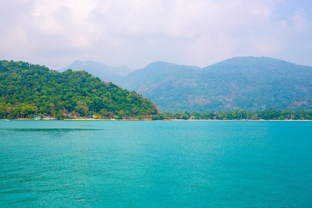 Beautiful tropical landscape. Blue sea and mountains overgrown with vegetation on the coast.