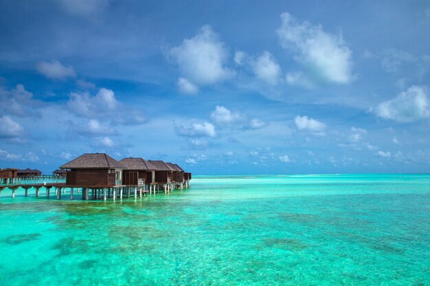 Beautiful tropical Maldives island with beach. Sea with water bungalows