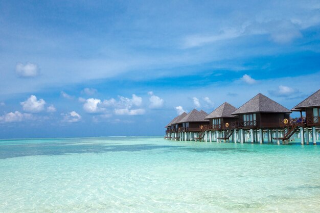 Beautiful tropical Maldives island with beach. Sea with water bungalows