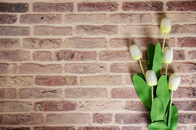 Beautiful tulips on brick wall background Lovely greeting card with tulips for Mothers day