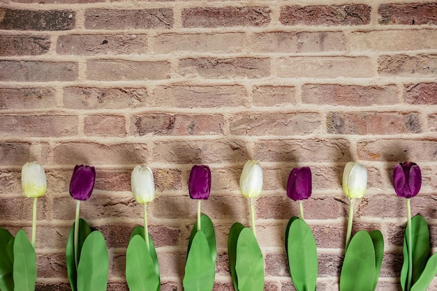 Beautiful tulips on brick wall background Lovely greeting card with tulips for Mothers day