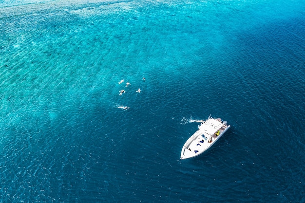 Beautiful turquoise ocean water and boat, view aerial drone seascape. Tropical sea waves, amazing