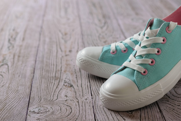 Beautiful turquoise sneakers on the wooden floor.