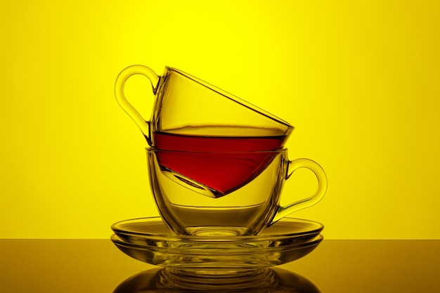 Beautiful two cups with tea on a yellow background