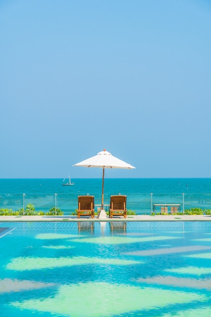 Beautiful umbrella and chair around swimming pool in hotel and resort