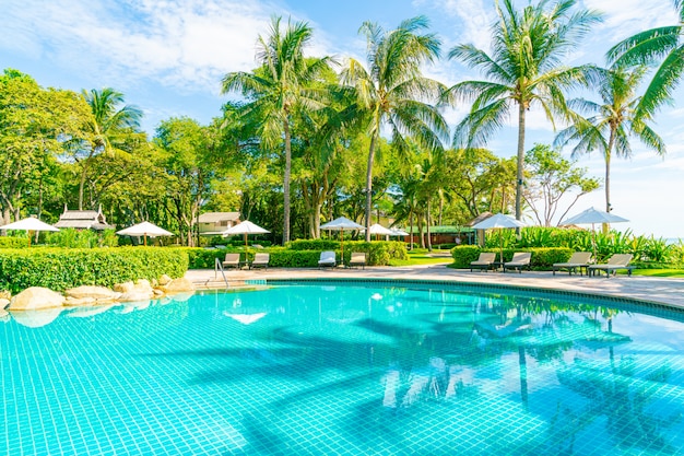 Beautiful umbrella and chair around swimming pool in hotel and resort