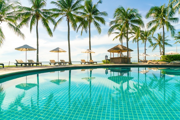 Beautiful umbrella and chair around swimming pool in hotel and resort