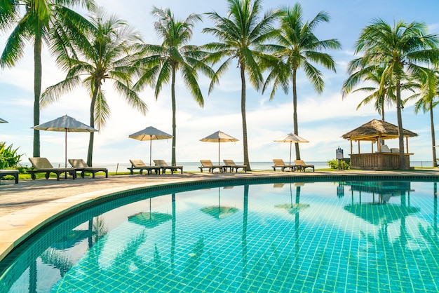 Beautiful umbrella and chair around swimming pool in hotel and resort