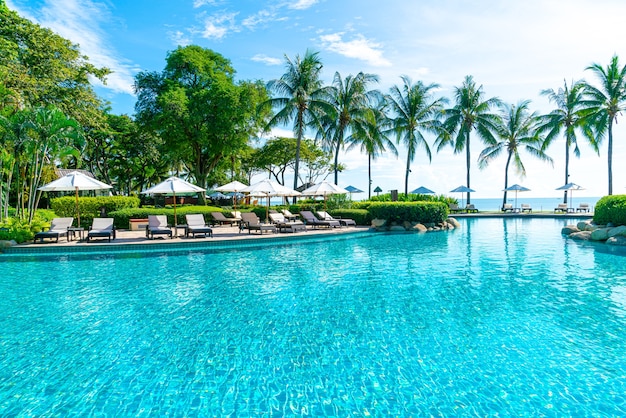 Beautiful umbrella and chair around swimming pool in hotel and resort