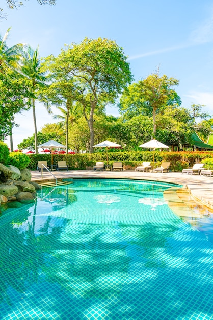 Beautiful umbrella and chair around swimming pool in hotel and resort