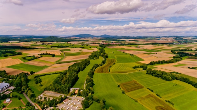 Beautiful view of agricultural fields and blue sky with white clouds. Aerial view.