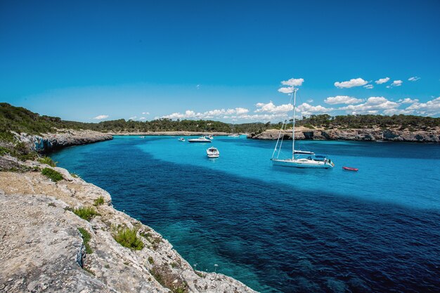 Beautiful view of the bay with turquoise water and yachts in Cala Mondrago National Park on Mallorca island, Spain.