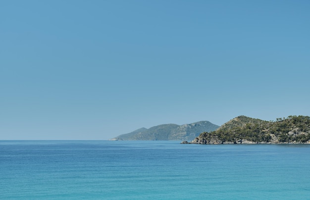 Beautiful view of the blue sea and islands in a deserted place on the coast of the sea blue clear sky on a sunny day Summer tropical vacation on the Aegean Sea panoramic view