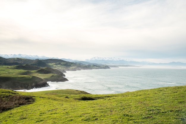 Beautiful view of a cliff green hill and the waves of the atlantic ocean in north Spain