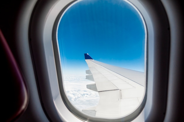 Beautiful view of Cloudscape and airplane wing seen through window of an airplane 