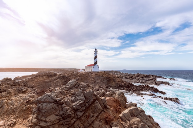 Beautiful view of famous lighthouse Faro de Favaritx  under the sky with clouds on the island of Menorca, Balearic islands, Spain