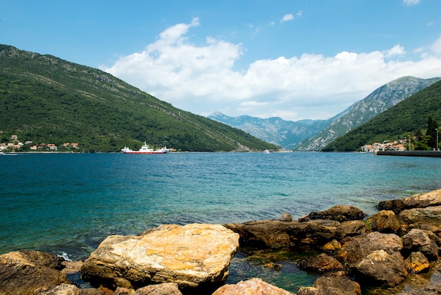 Beautiful view from above to Kotor Bay and regular passenger ferry from Lepetane to Kamenari by a sunny afternoon.