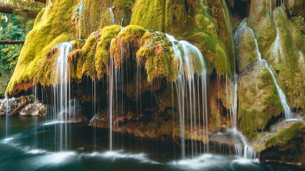 Beautiful view of a waterfall over the moss-covered rocks on a river