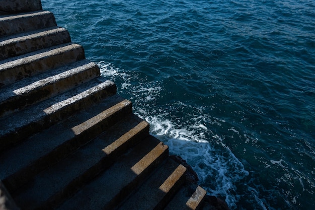 Beautiful vintage concrete staircase to the ocean with waves Light and shadow minimalism photo