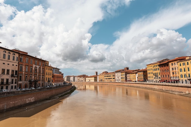 Beautiful vintage European city of Pisa Italy with ancient houses river and bridge in cloudy summer day