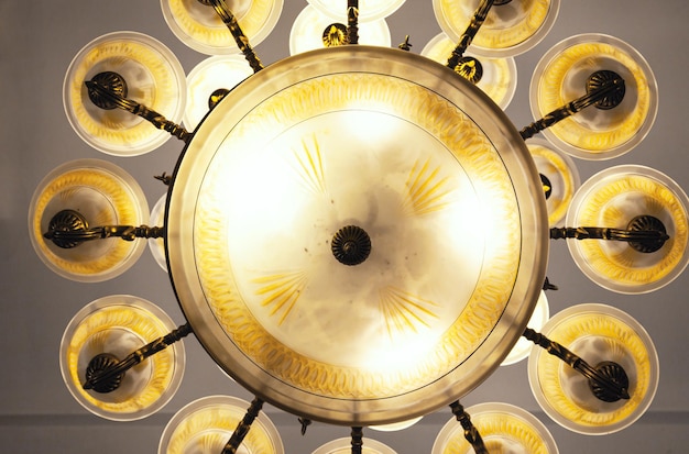 A beautiful vintage style chandelier hangs on the ceiling and shines closeup