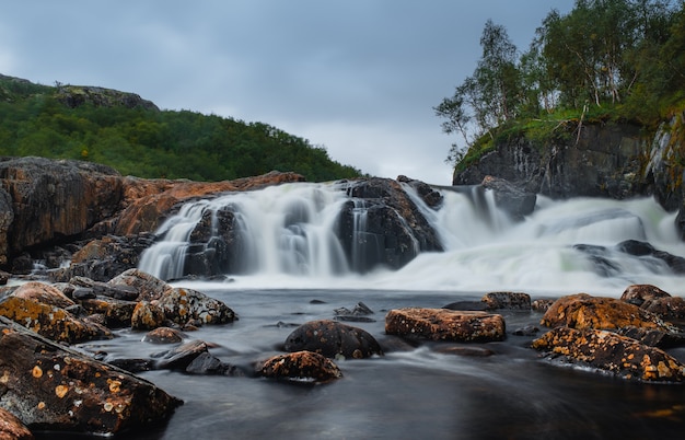 Beautiful waterfall on titovka river in kola peninsula tundra, after the spring rains