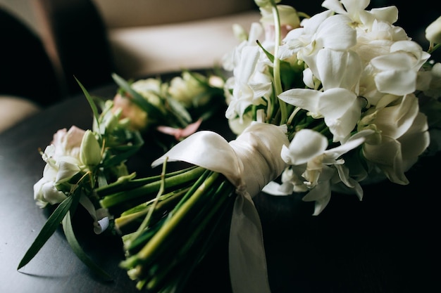 A beautiful wedding bouquet of brides from white flowers on a dark wooden backgroundx9