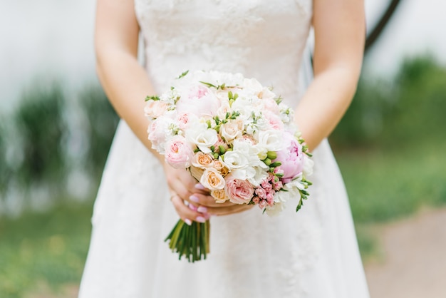 Beautiful wedding bouquet in the hands of a bride 