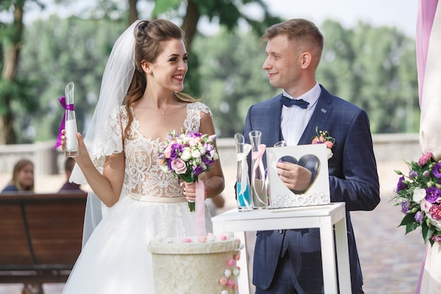 beautiful wedding ceremony outdoors in sunny day. happy bride and groom  exchange with wedding rings.