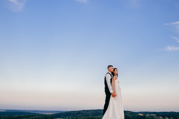 Beautiful wedding couple hugging outdoor.