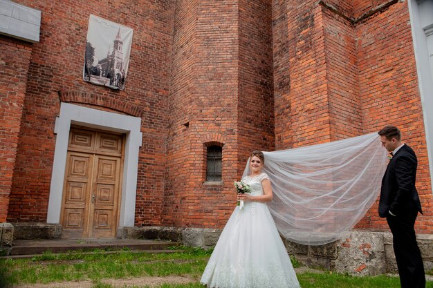 Beautiful wedding couple posing near the wall