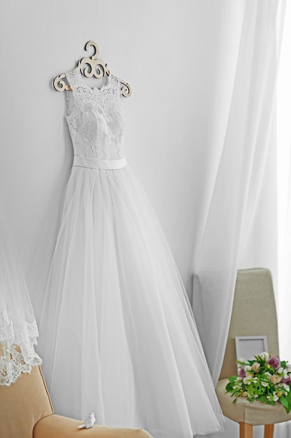 Beautiful wedding dress on hanger in room