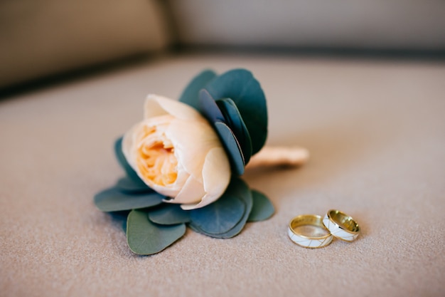 Beautiful wedding rings and bridal bouquet lying