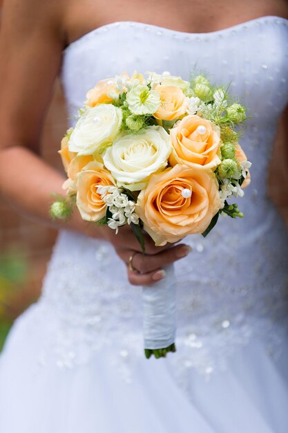 Beautiful wedding roses bouquet in hands of the bride