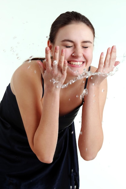 Beautiful wet woman face with water drop Closeup portrait on white background