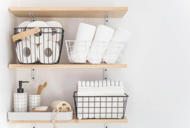 Beautiful white bathroom wooden shelves rolled towels stacked towels and baskets soap washcloth