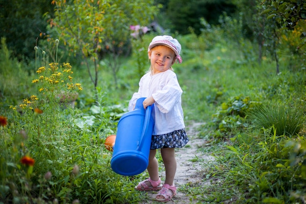 Beautiful white girl watering flowers from watering can