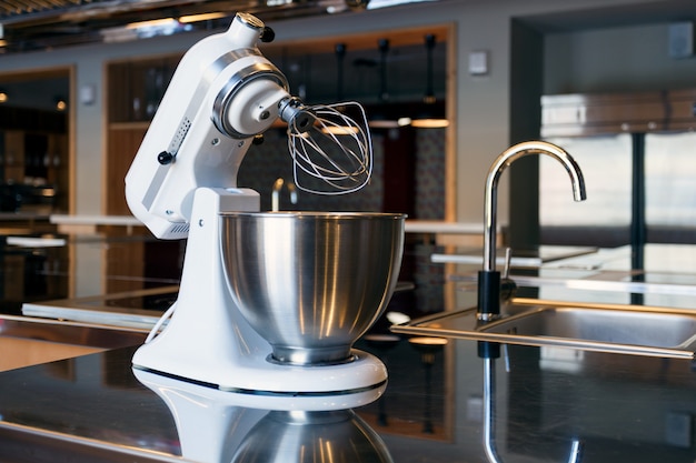 A beautiful white mixer with a metal cup 