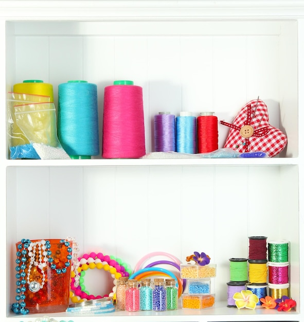 Beautiful white shelves with thread and material for handicrafts