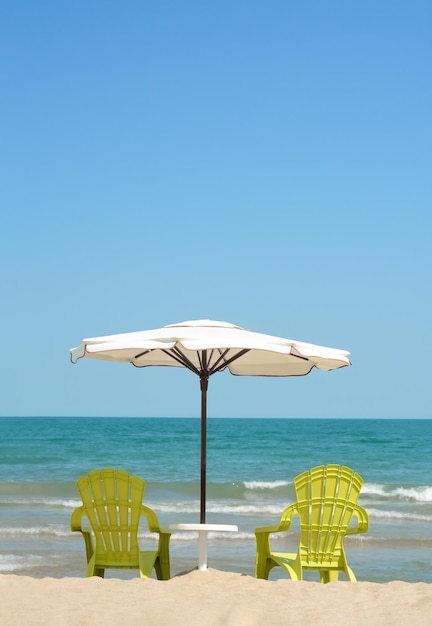 Beautiful white umbrella and chairs on sandy beach