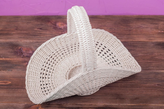 Beautiful white vintage wicker basket on a wooden table