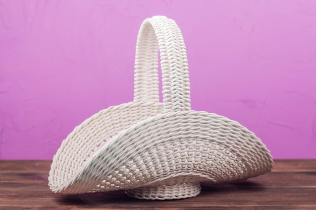 Beautiful white vintage wicker basket on a wooden table